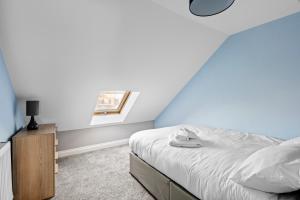 um quarto com uma cama e uma parede azul em Cosy 2 Bedroom Flat in East Ham, Close to Excel em Londres