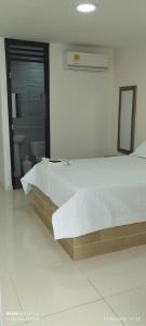 a bedroom with a large bed and a bathroom at Habitaciones Cataleya Valledupar in Valledupar