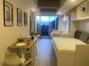 um pequeno quarto com uma cama e uma mesa em Maravilloso loft con vista al atardecer - 707 em Bogotá