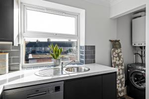 a kitchen with a sink and a window at Cosy 2 Bedroom Flat in East Ham, Close to Excel in London