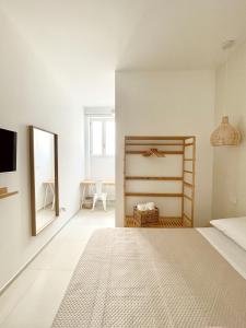 Habitación blanca con cama y espejo en Camere Assúd en Leuca