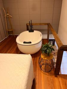 a bedroom with a bed and a tub in a room at Lofts Urbano in Urubici
