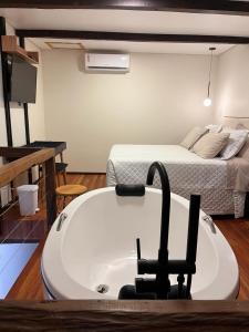 uma banheira num quarto com uma cama em Lofts Urbano em Urubici