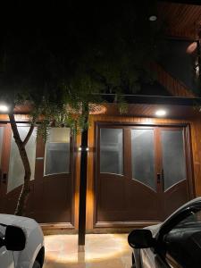 a house with a wooden garage with a car parked in front at Lofts Urbano in Urubici