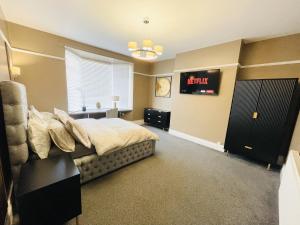 a bedroom with a bed and a clock on the wall at Serenity By The Sea, Stylish Two Bedroom Apartment Near The Beach, South Shields in South Shields +30 photos