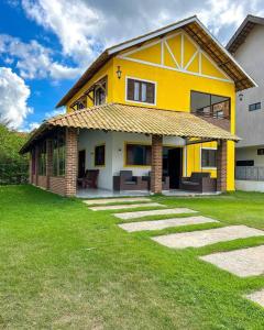 a yellow house with a grass yard at Casa em Bananeiras PB in Bananeiras