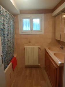 een badkamer met een wastafel, een raam en een douche bij Casa Tranquila Cerca el Estuario in Pauillac