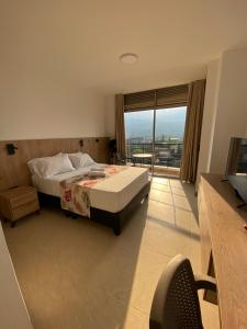a bedroom with a bed and a large window at Caliview Apartahotel in Cali