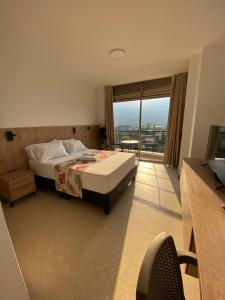 a bedroom with a bed and a large window at Caliview Apartahotel Andalaya in Cali