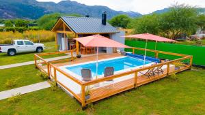 una casa con una piscina con terraza y una casa en Cabañas & Apart Del Sauce en El Hoyo