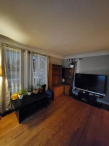 een woonkamer met een grote flatscreen-tv bij A Place to Call Home in Edmonton