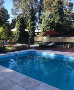 a swimming pool with blue water in a yard at La Posada Encantada in Mar del Plata
