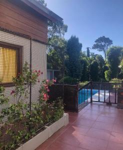 une clôture en face d'une maison avec piscine dans l'établissement La posada de las brujas, à Mar del Plata