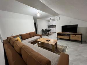 sala de estar con sofá y TV de pantalla plana en Villa JETA, en Prevallë