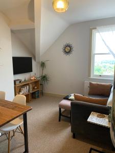 ein Wohnzimmer mit einem Sofa und einem TV in der Unterkunft The Nest, central Ludlow one bed apartment in Ludlow