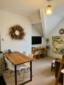 ein Wohnzimmer mit einem Holztisch und Stühlen in der Unterkunft The Nest, central Ludlow one bed apartment in Ludlow