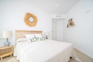 een witte slaapkamer met een wit bed en een spiegel bij MARIVENT 2023 in Roses