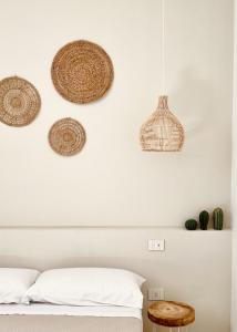 1 dormitorio con cestas de ratán en la pared en Camere Assúd en Leuca