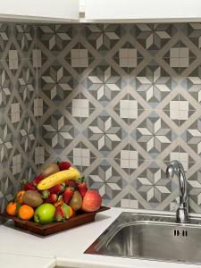 un vassoio di frutta su un bancone accanto a un lavandino di Residenza Trevisani a Bari