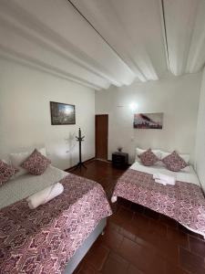 a room with two beds and a cross on the wall at Hostal greenlandomesa in Piedecuesta