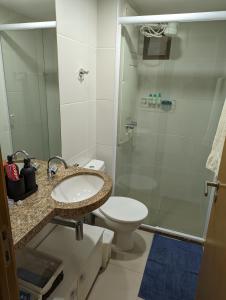 y baño con aseo, lavabo y ducha. en Moderno apartamento perto da praia en Maceió