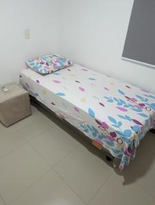 a bed in a room with a pillow on it at Moderno apartamento perto da praia in Maceió