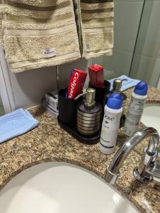 a bathroom counter with a sink with hygiene products on it at Moderno apartamento perto da praia in Maceió