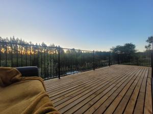 eine Person, die auf einer Holzterrasse mit einem Zaun liegt in der Unterkunft Hilltop Rural Retreat in Loburn