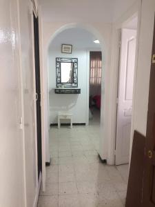 a hallway with an archway and a mirror on the wall at Home2Home in Nabeul