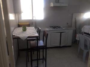 een keuken met een tafel en stoelen en een fornuis bij Home2Home in Nabeul