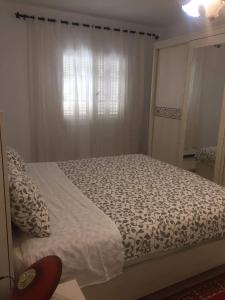 een slaapkamer met een bed en een raam bij Home2Home in Nabeul