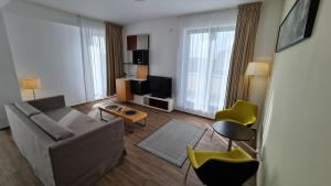 ein Wohnzimmer mit einem Sofa und einem TV in der Unterkunft Jafar Resort 9 Penthouse in Timişoara