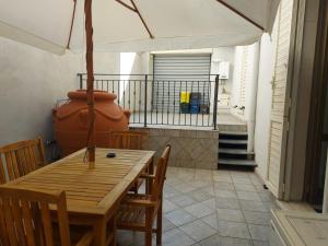 een houten tafel met stoelen en een vaas op een balkon bij Arte Mia B&B in Reggio di Calabria