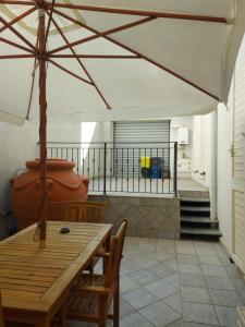 patio con tavolo, sedie e ombrellone di Arte Mia B&B a Reggio di Calabria