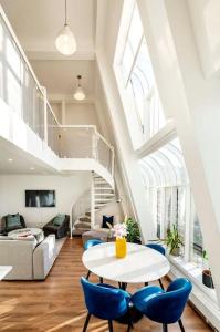 ein Wohnzimmer mit einem weißen Tisch und blauen Stühlen in der Unterkunft Arcore Premium Apartments Golden Square in London