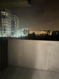 una recinzione bianca con skyline della città di notte di Apartament JANICKIEGO 159 a Poznań