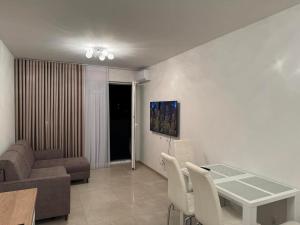 a living room with a couch and a table and chairs at Apartament JANICKIEGO 159 parking free in Poznań
