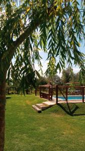 a wooden fence in a park with a swimming pool at Cabañas El Sauce in Albardón