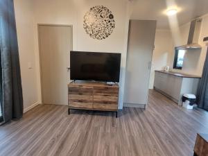 a living room with a flat screen tv on a wooden dresser at Hilltop Rural Retreat in Loburn