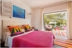 a bedroom with a bed and a large window at Villa Leonor in Es Caló