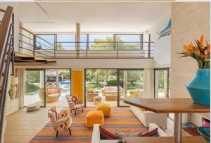 a living room with a staircase and a living room with orange chairs at Villa Leonor in Es Caló