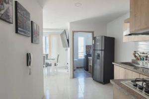 a kitchen with a refrigerator and a dining room at Hermoso apto cerca al centro in Cartago