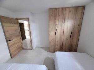 a bedroom with a bed and a wooden door at Hermoso apto cerca al centro in Cartago +3 photos
