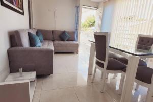 a living room with a couch and a glass table at Hermoso apto cerca al centro in Cartago
