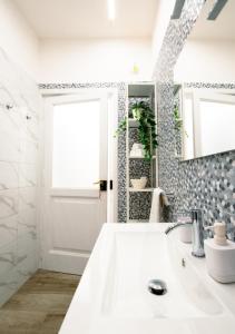 bagno con lavandino bianco e specchio di Casa Cosmedin a Napoli