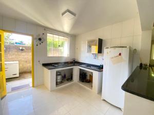 a kitchen with a white refrigerator and a sink at Casa de campo in Valença