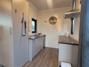 uma cozinha com armários brancos e um lavatório em Hilltop Rural Retreat em Loburn