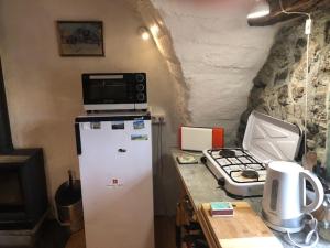 eine Küche mit einer Mikrowelle auf dem Kühlschrank in der Unterkunft Maison basse in Vars