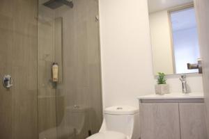 een badkamer met een douche, een toilet en een wastafel bij Loft con vista 180° en Centro Internacional 1224 in Bogota