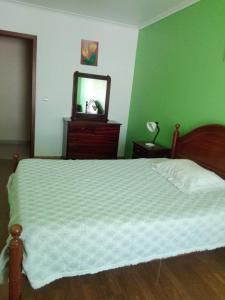 a bedroom with a bed with a dresser and a mirror at Casa Modesta II in Beja